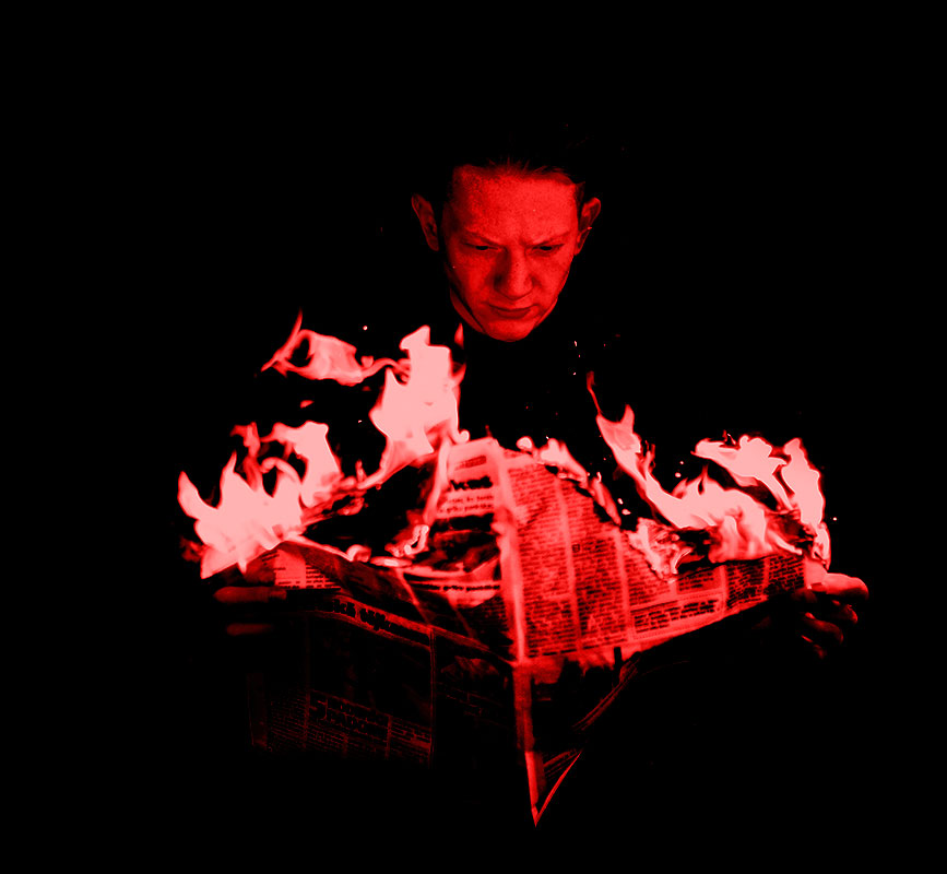Man reading a newspaper on fire - RedHot Copy